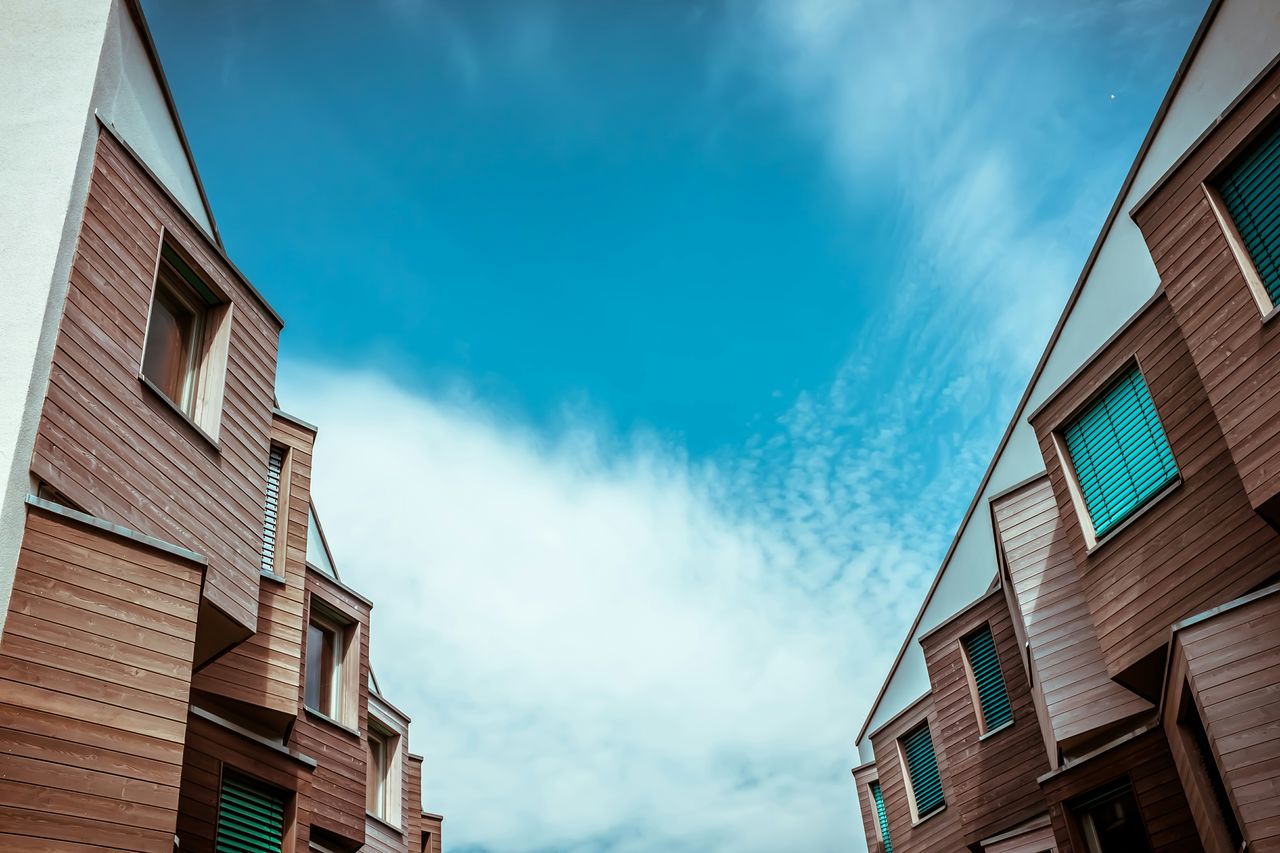 Low angle view of buildings against cloudy sky