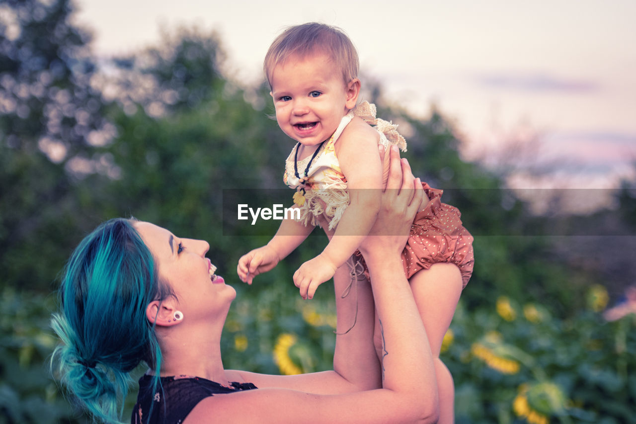 Smiling mother playing with daughter