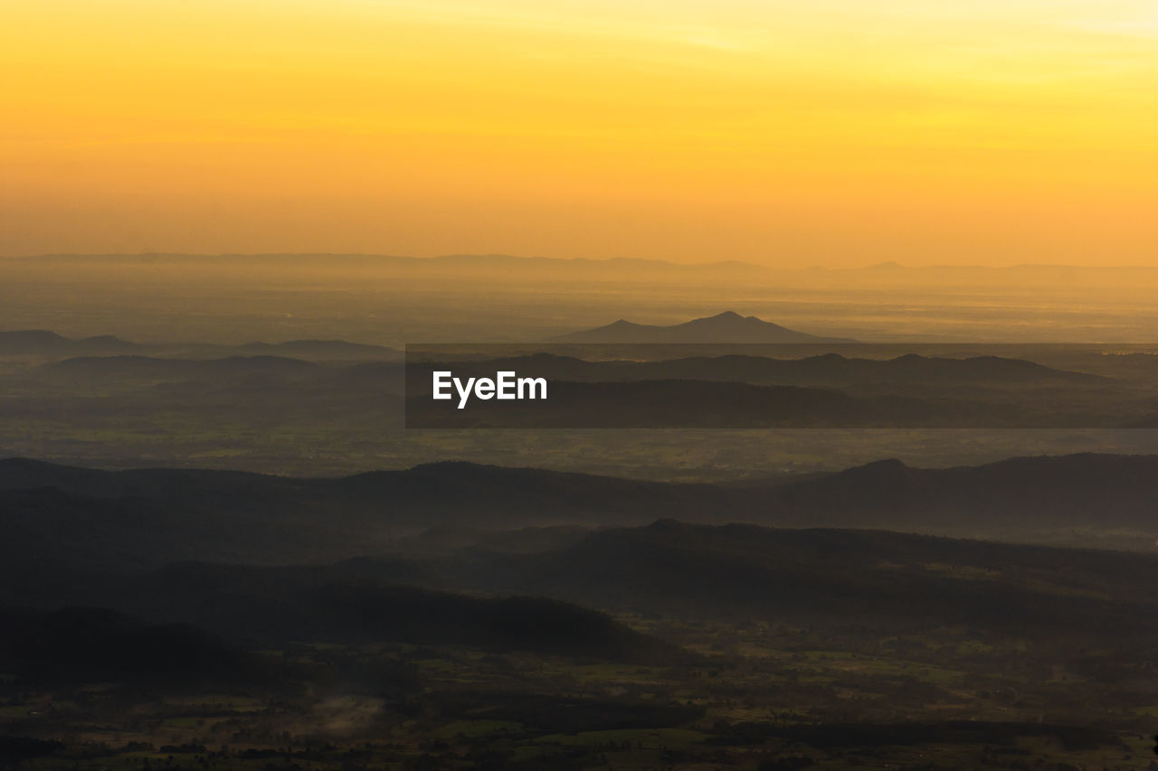 SCENIC VIEW OF MOUNTAINS AGAINST ORANGE SKY