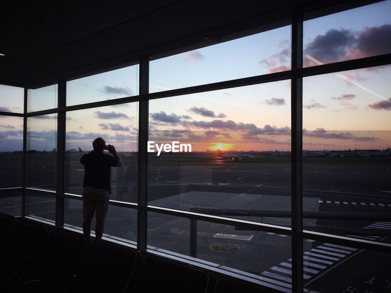 Rear view of silhouette man standing against sunset