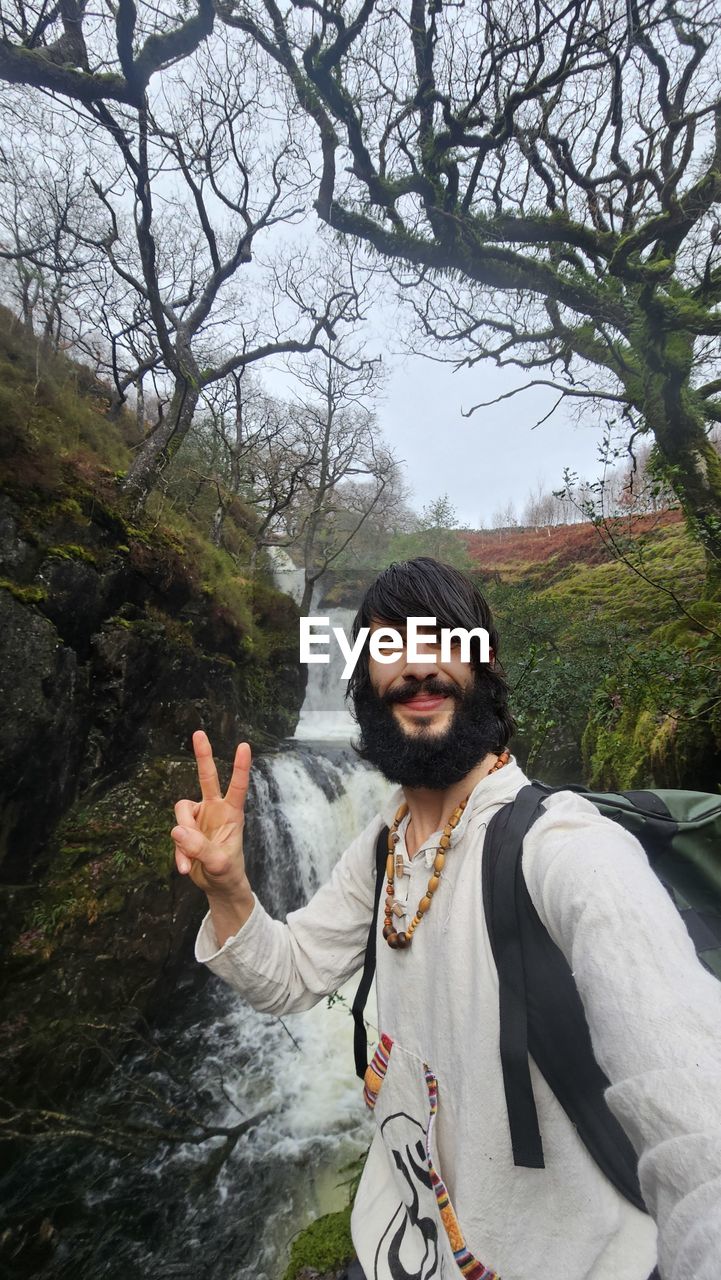 Low angle view of man standing against  a waterfall 