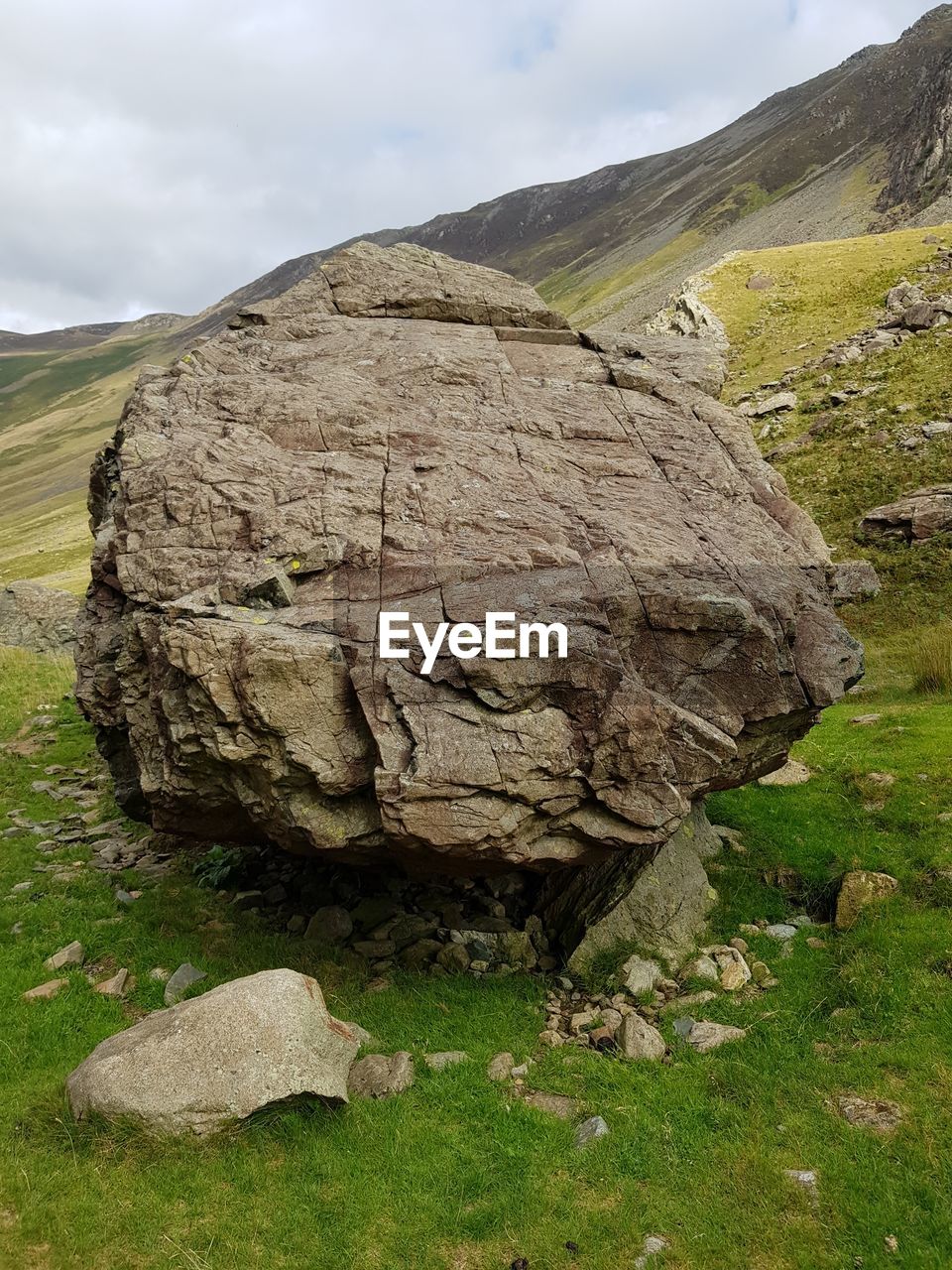 SCENIC VIEW OF ROCK FORMATION ON FIELD AGAINST SKY