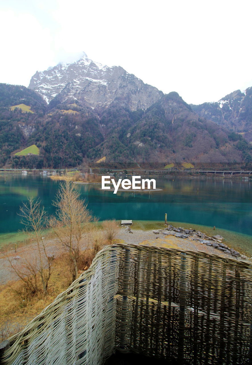 SCENIC VIEW OF LAKE AGAINST MOUNTAIN RANGE