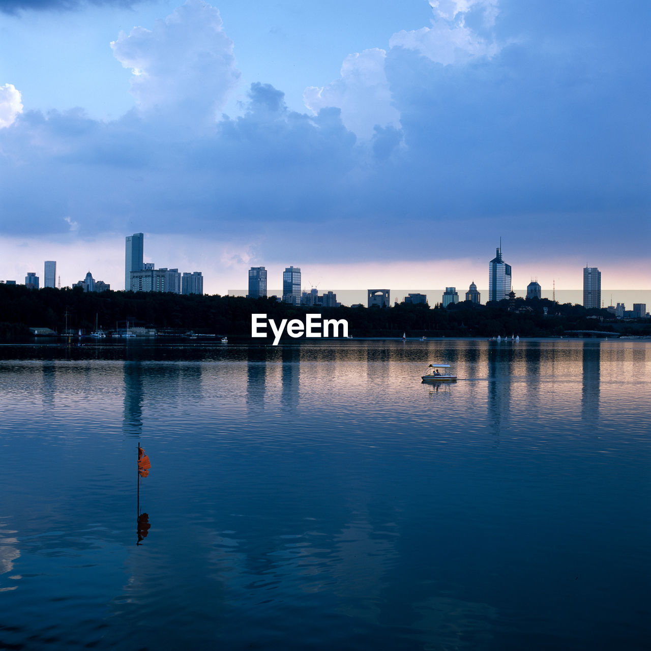 BUILDINGS BY RIVER AGAINST SKY