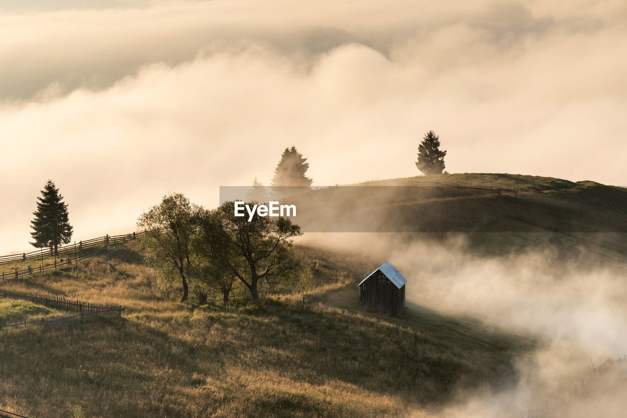 Hut on mountain against sky