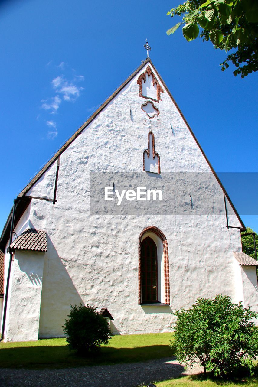 architecture, building exterior, built structure, place of worship, building, religion, nature, sky, plant, belief, house, no people, blue, sunlight, spirituality, day, tree, sunny, facade, clear sky, outdoors, history, travel destinations, catholicism, the past, rural area, cross, tower, low angle view, shadow, estate