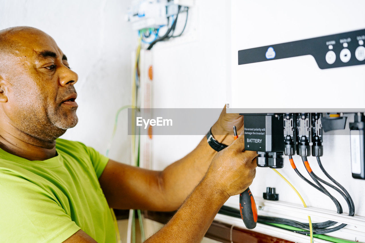 Mature engineer installing system in utility room