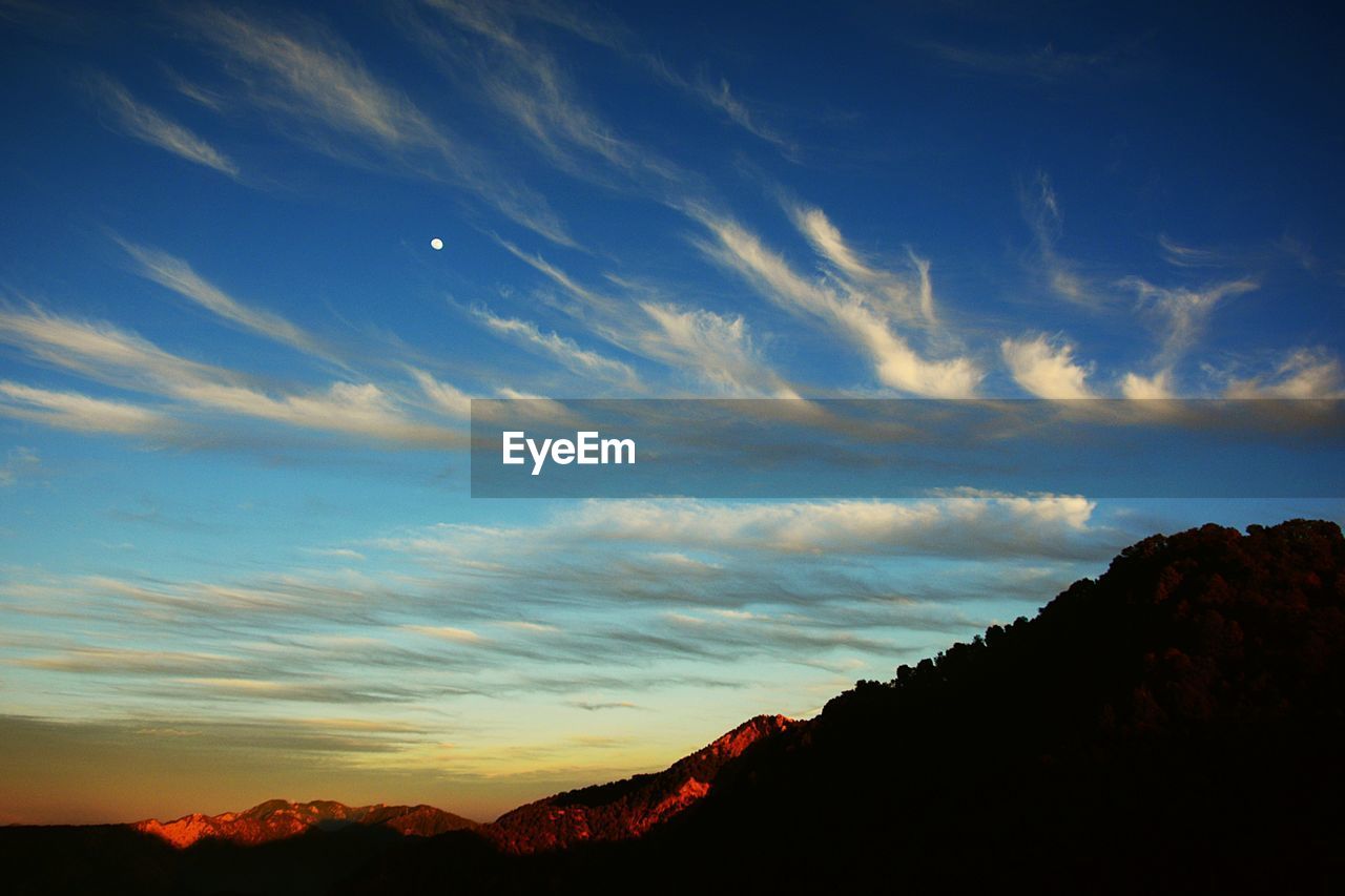 SCENIC VIEW OF SILHOUETTE MOUNTAIN AGAINST SKY DURING SUNSET