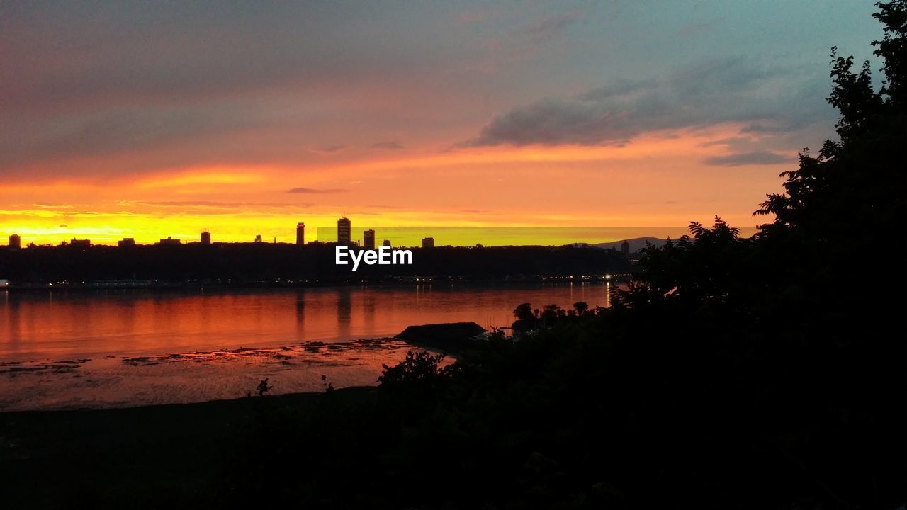 SCENIC VIEW OF SILHOUETTE BUILDINGS AGAINST SKY AT SUNSET