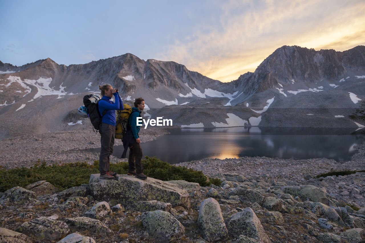 Women hikers watch sunset from pierre lakes, elk mountains, colorado