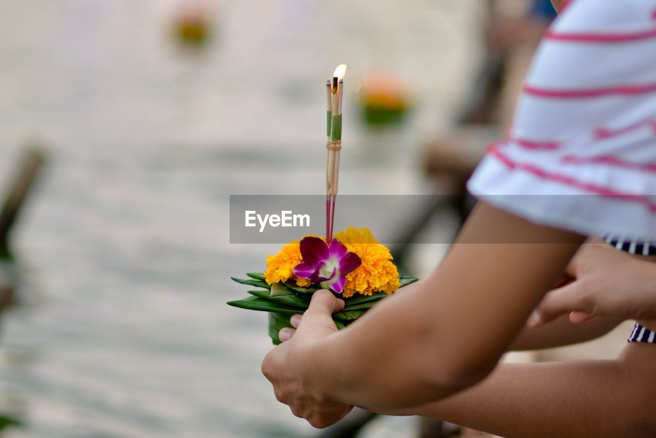 Cropped hands holding religious offerings