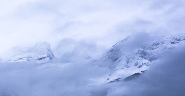 SNOW COVERED MOUNTAINS AGAINST CLOUDY SKY