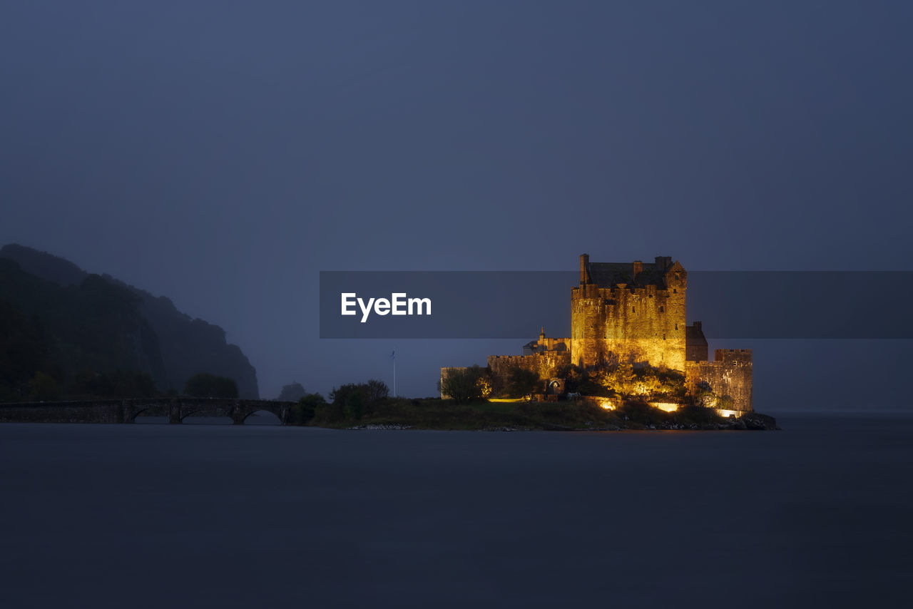 Illuminated castle against sky at dusk