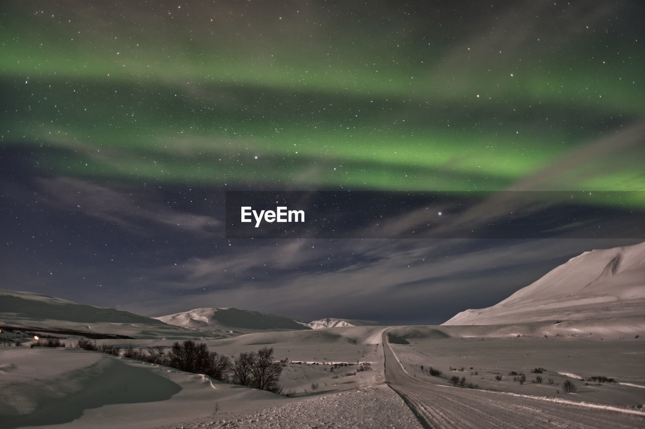 Snowy iceland at night with aurora borealis