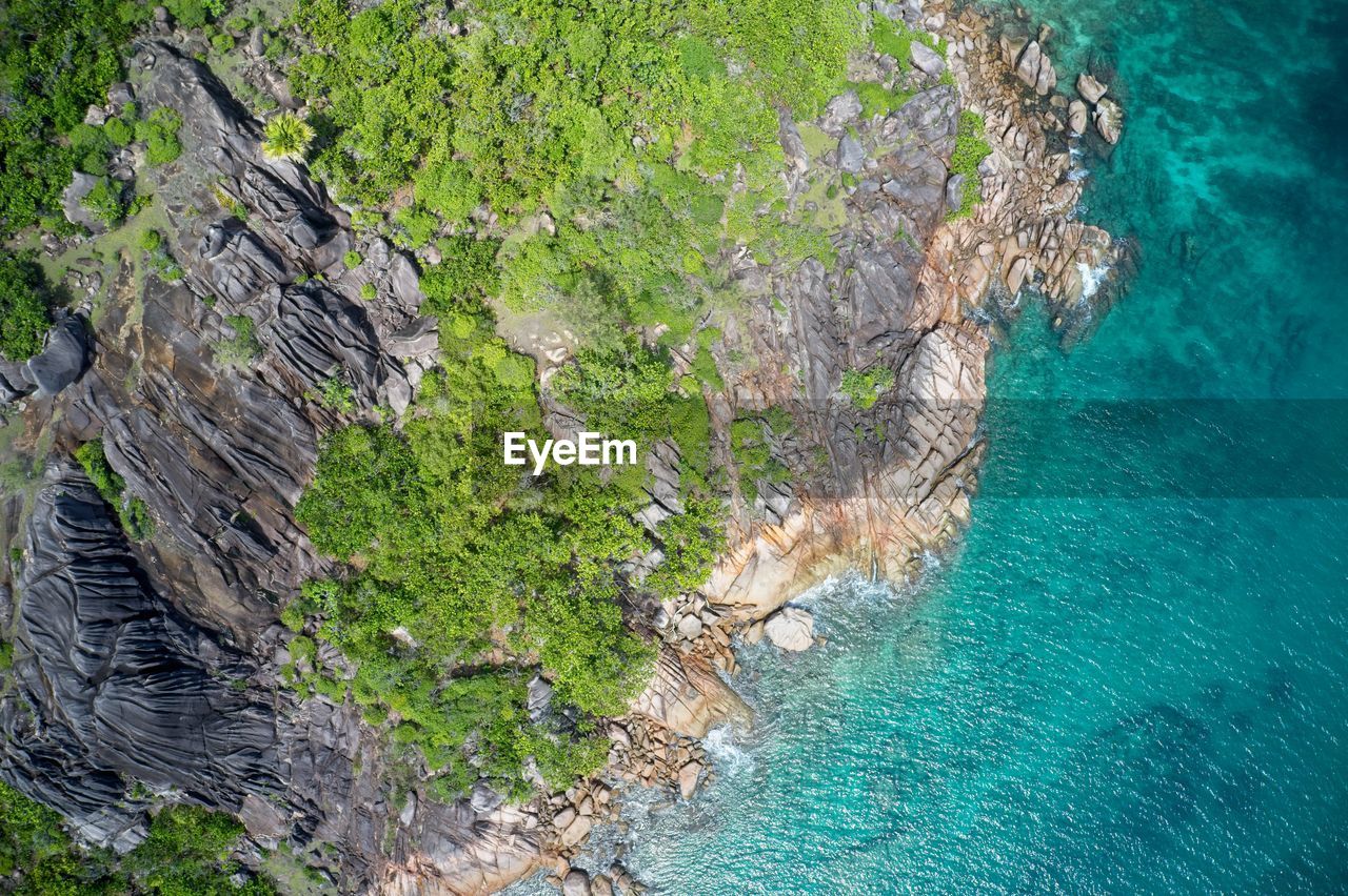 Drone field of view of spectacular blue coastline with waves and forest, seychelles.