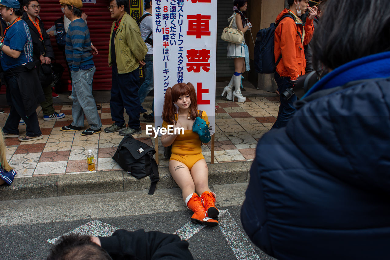 PEOPLE SITTING IN STREET