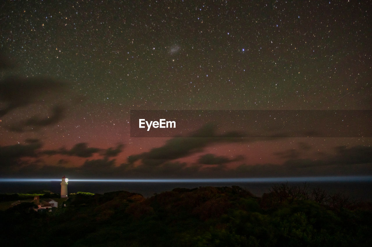 Aurora australis over  a lighthouse with a star filled night..