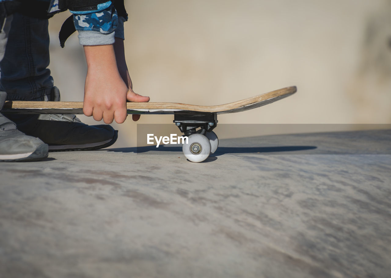 Low section of man with skateboard at park