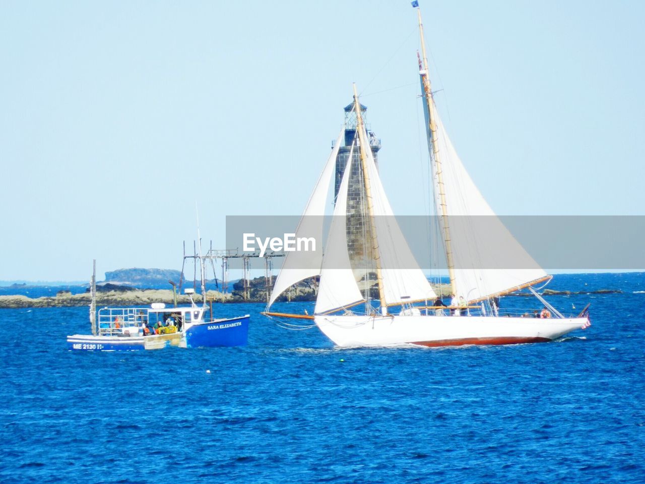 SAILBOATS IN SEA AGAINST CLEAR SKY