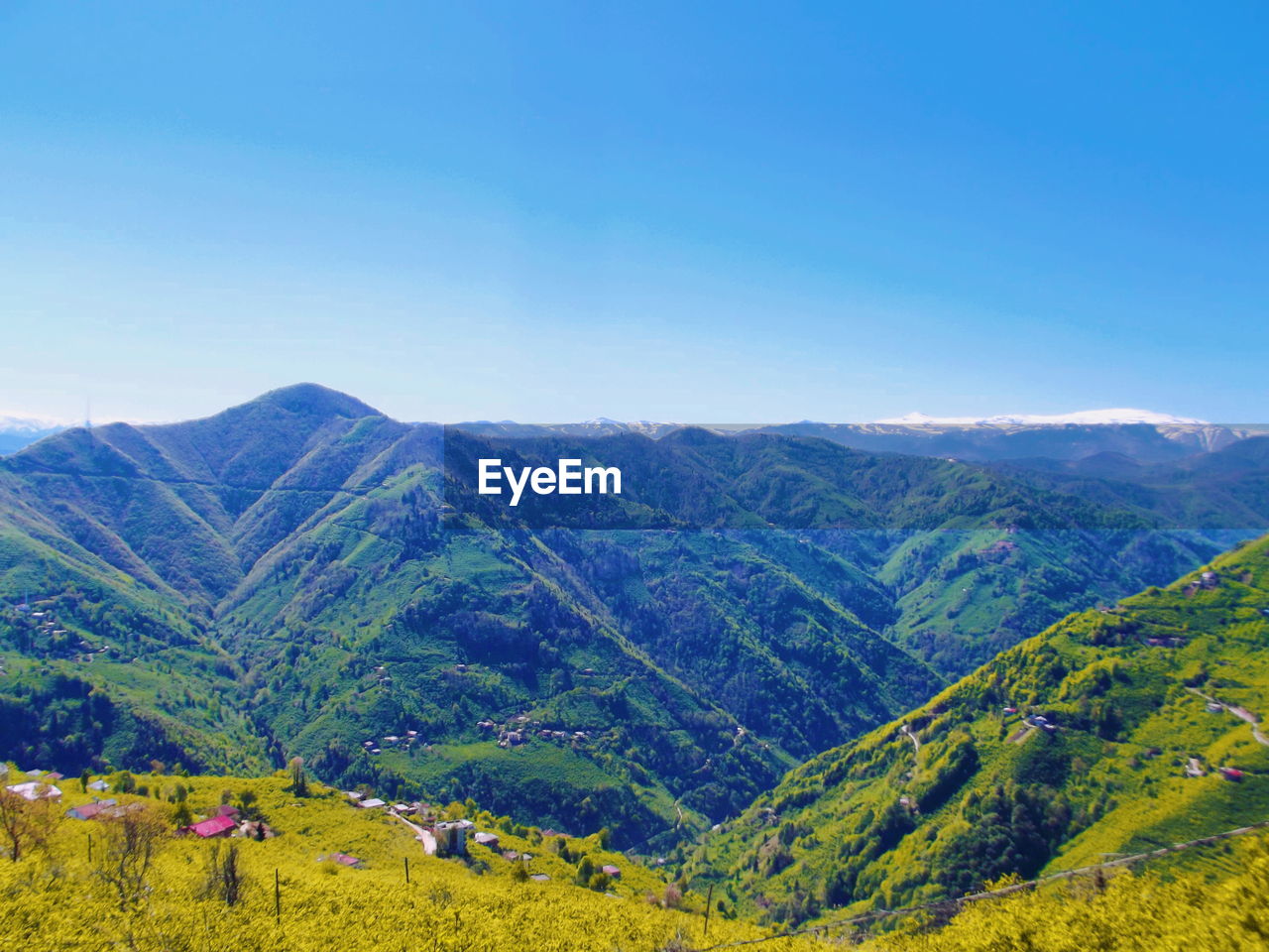 Scenic view of mountains against blue sky