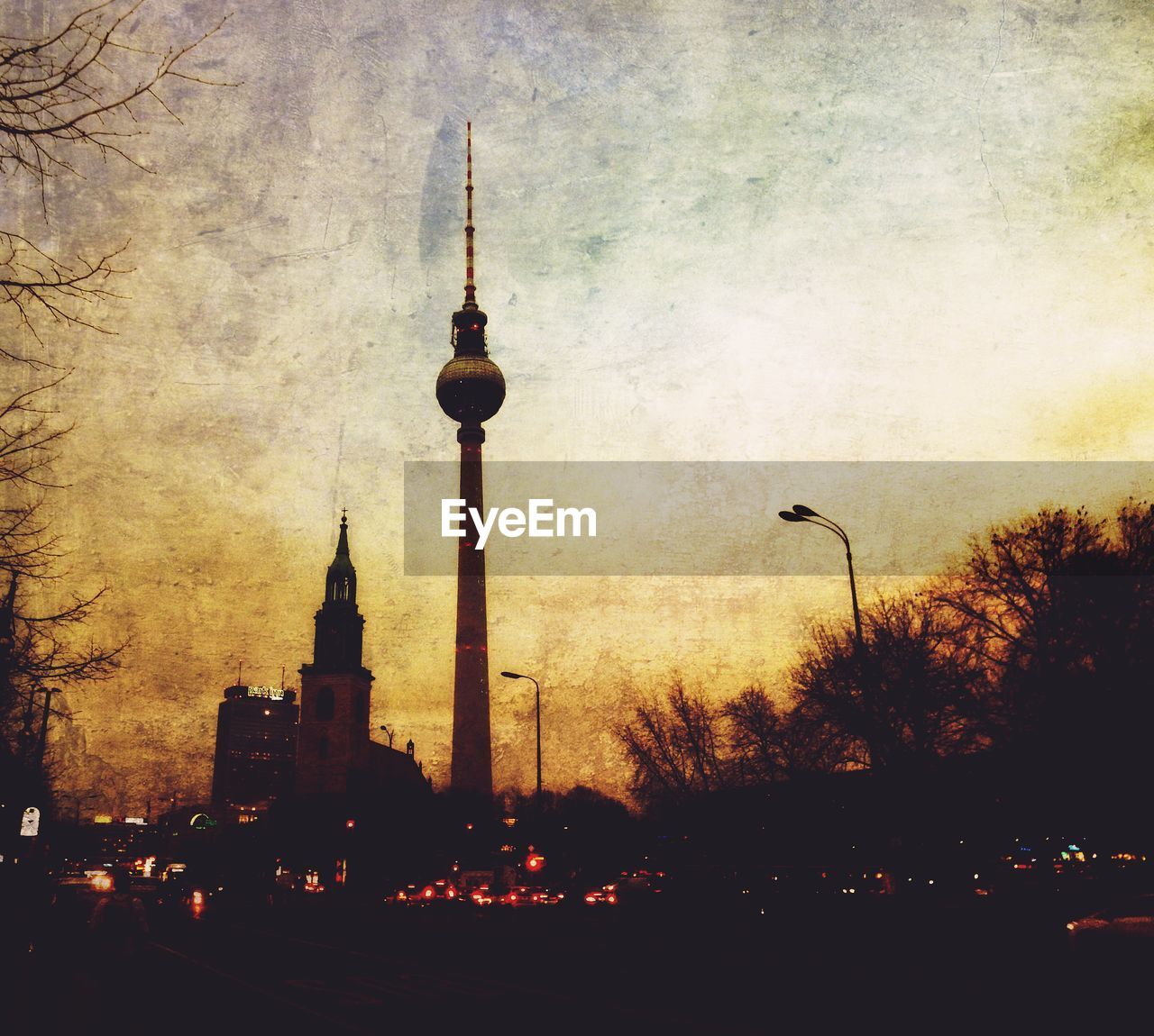 Low angle view of fernsehturm tower against cloudy sky at dusk