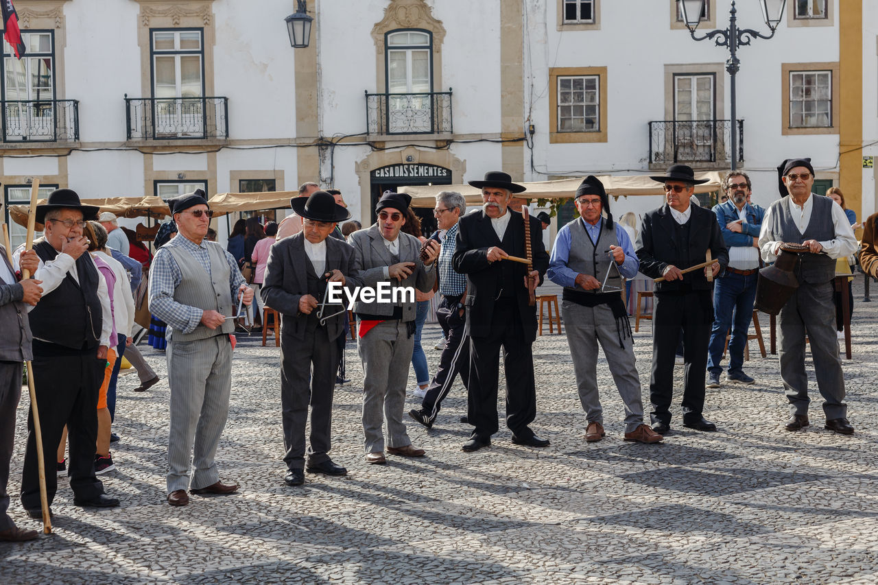 group of people, men, architecture, crowd, large group of people, city, building exterior, adult, built structure, full length, business, standing, street, social group, day, women, businessman, occupation, person, building, togetherness, clothing, outdoors