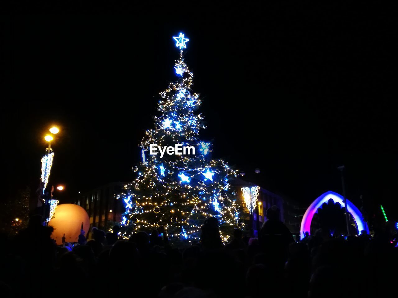 ILLUMINATED CHRISTMAS TREE AGAINST SKY