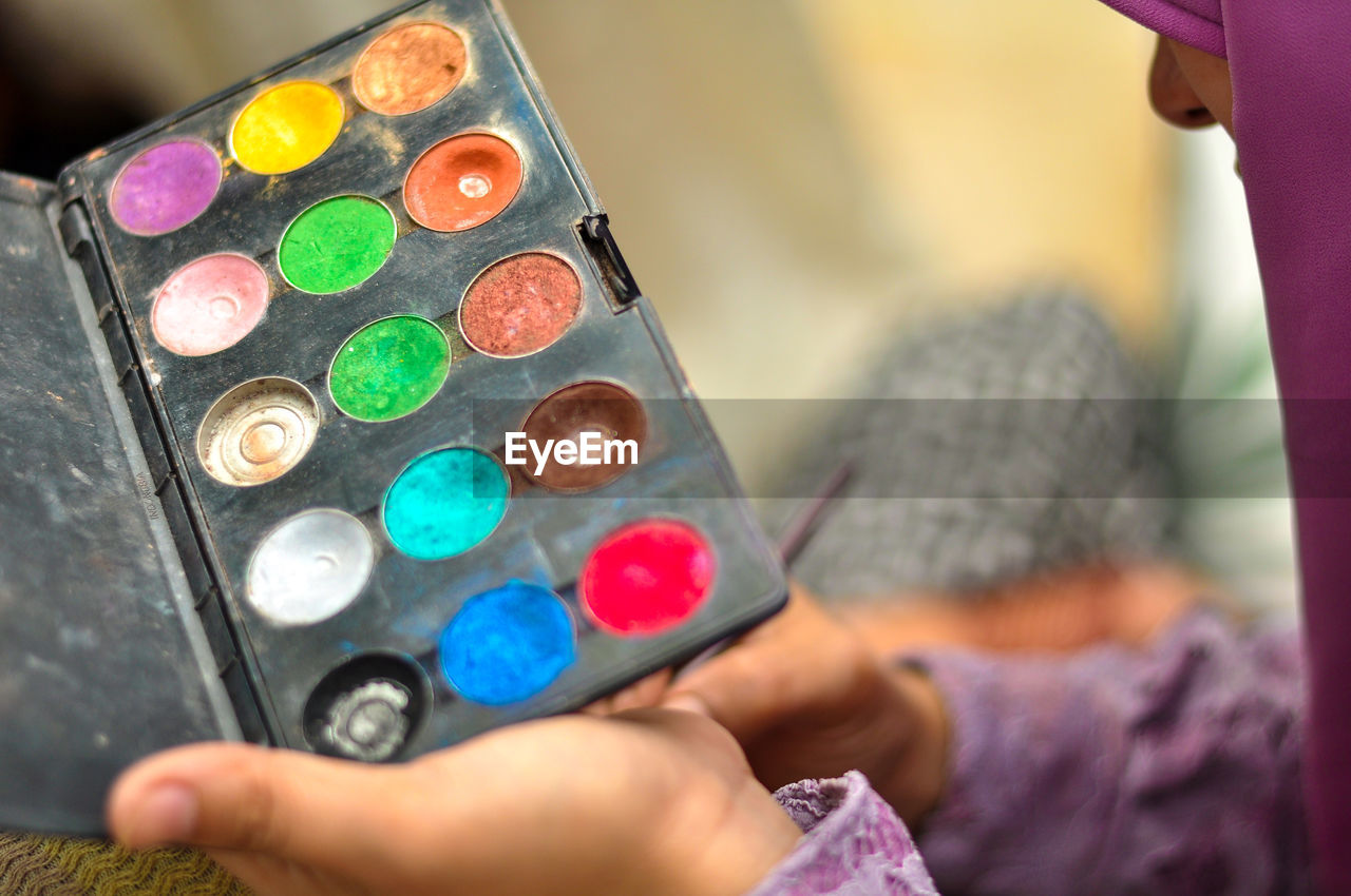 Close-up of woman holding eyeshadow palette