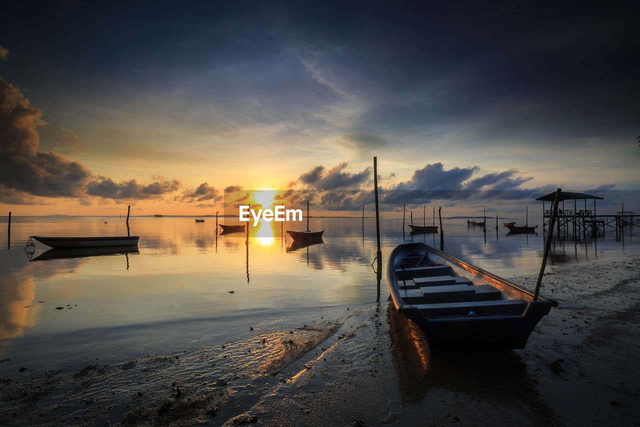 BOAT MOORED ON SEA AGAINST SUNSET SKY