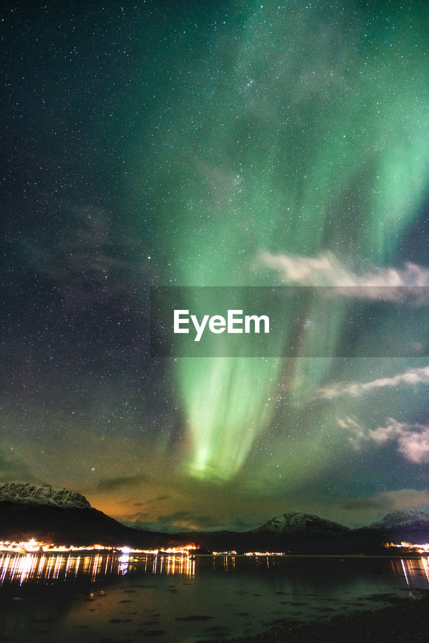 Northern lights dancing over the mountains at the sea