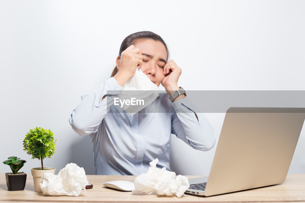 Crying businesswoman sitting at desk in office