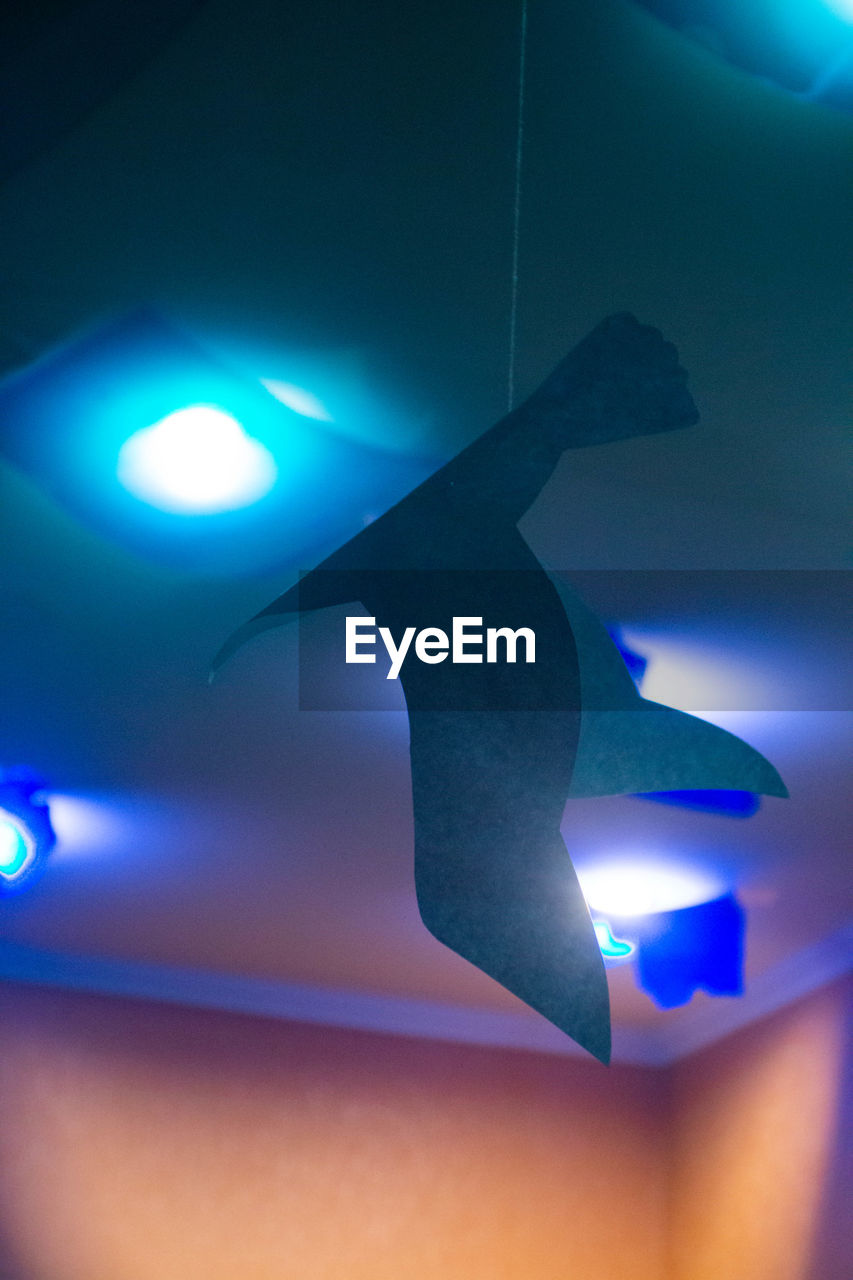 Low angle view of illuminated lighting equipment hanging on ceiling