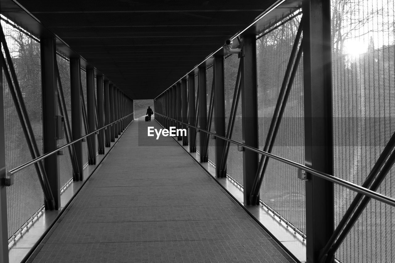 Mid distance of person walking on covered bridge