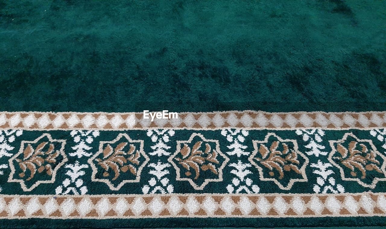 High angle view of green carpet with floral patterns