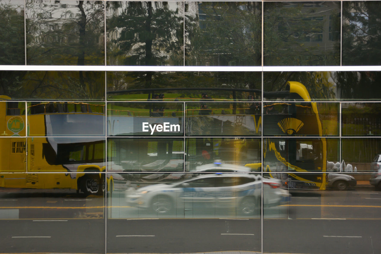 BLURRED MOTION OF PEOPLE WALKING ON ROAD BY CARS