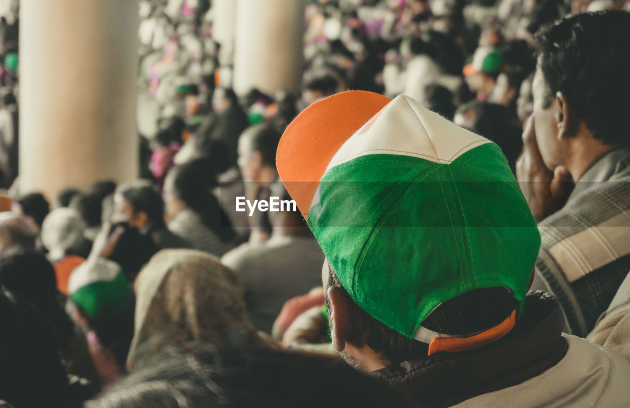 Man is wearing an indian tricolor cap outdoors in the stadium