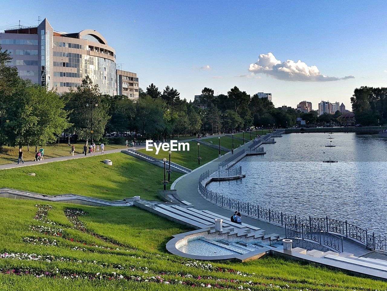 Lake in park at city against sky