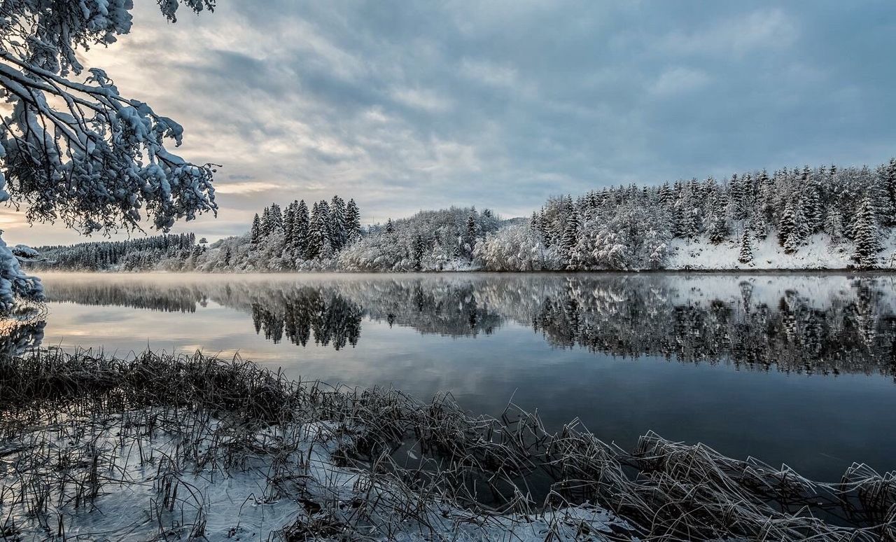 Scenic view of lake against sky during winter