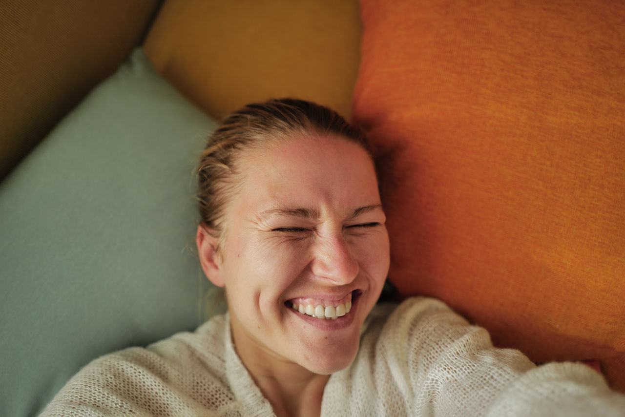 Woman relaxing on the colorful pillows smiling