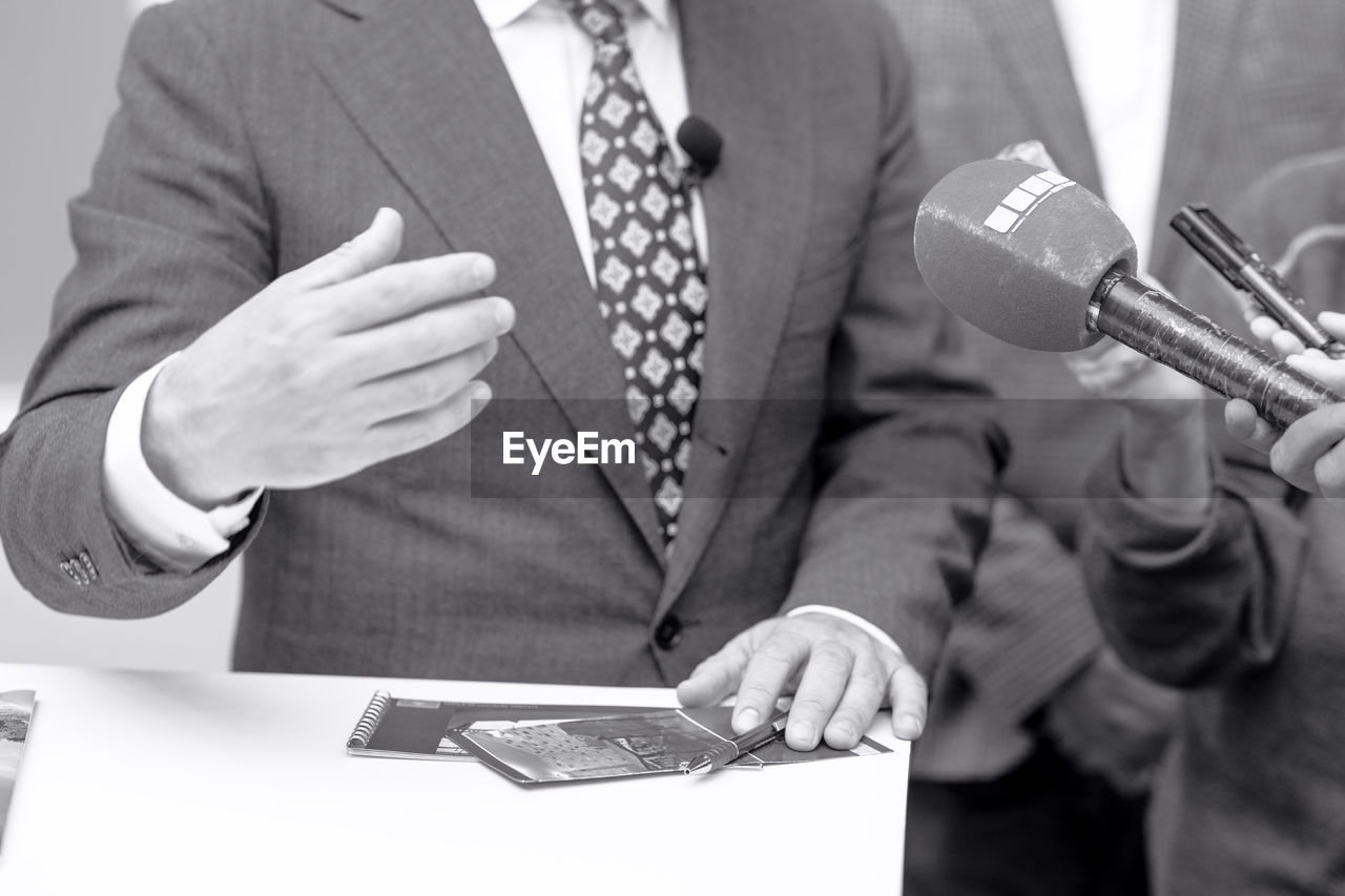 Microphone in focus, news or press conference or media interview with businessman