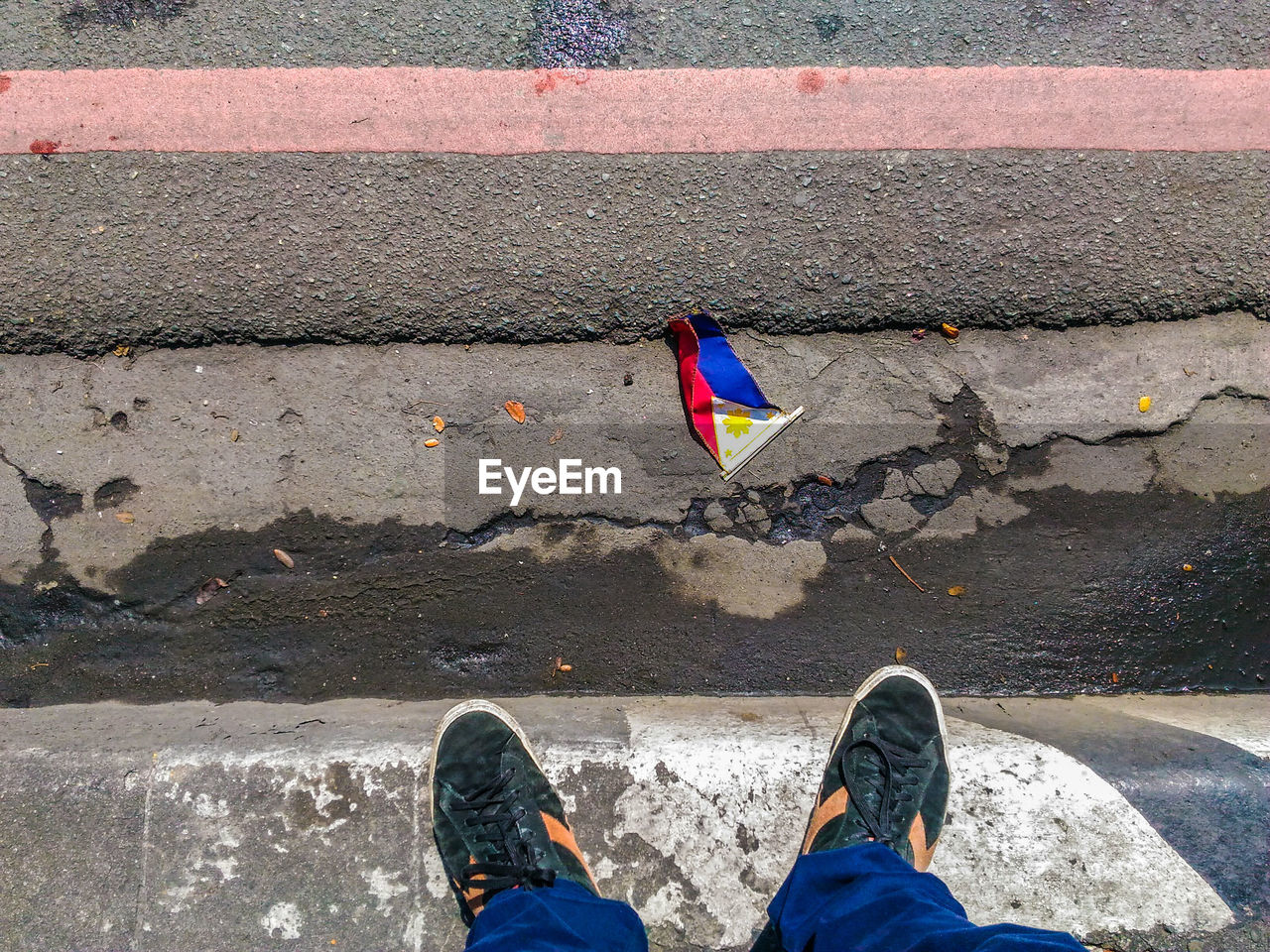 Low section of man standing in front of philippines flag on street