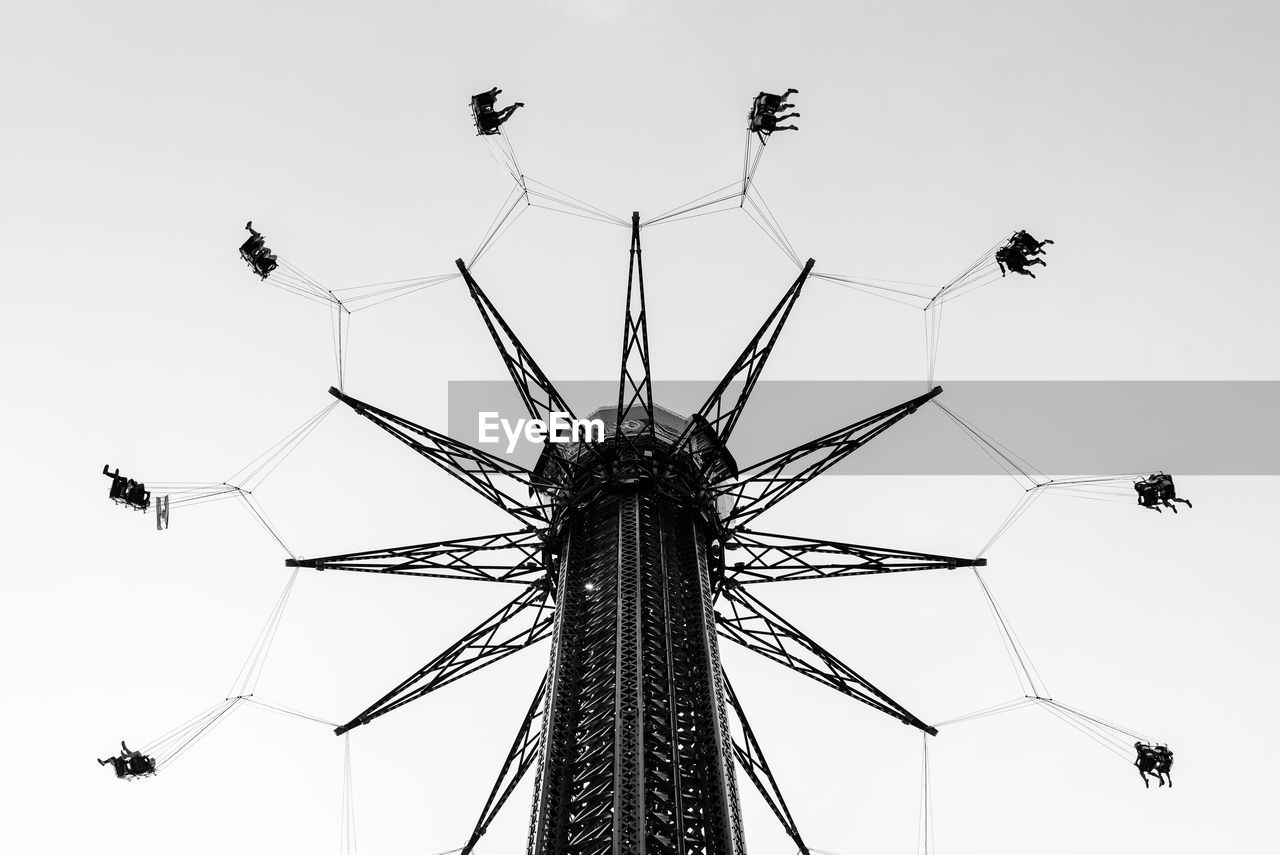 Low angle view of chain swing ride against sky