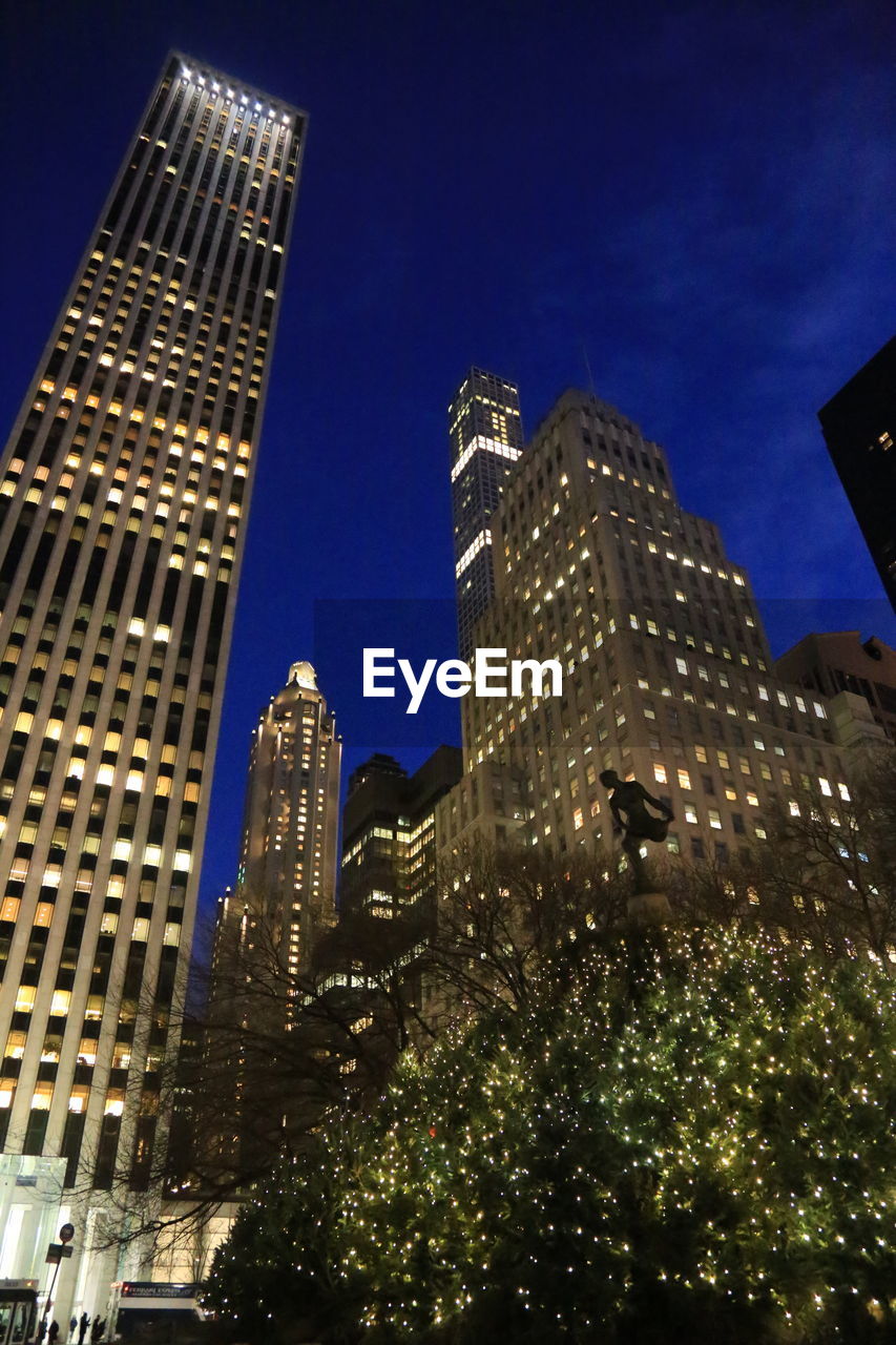 LOW ANGLE VIEW OF ILLUMINATED SKYSCRAPERS AGAINST CLEAR SKY