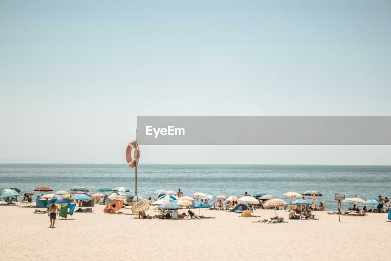 People at beach against sky