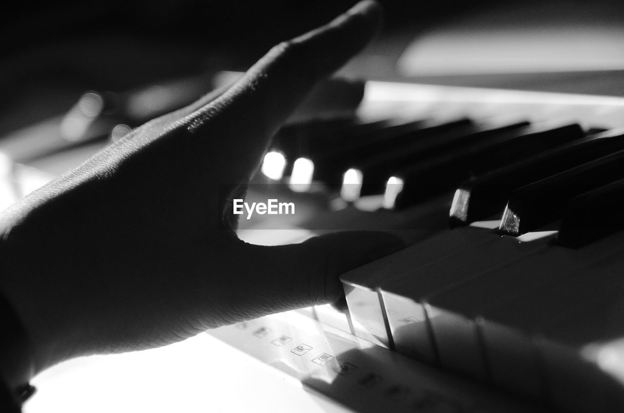 Close-up of hand playing piano