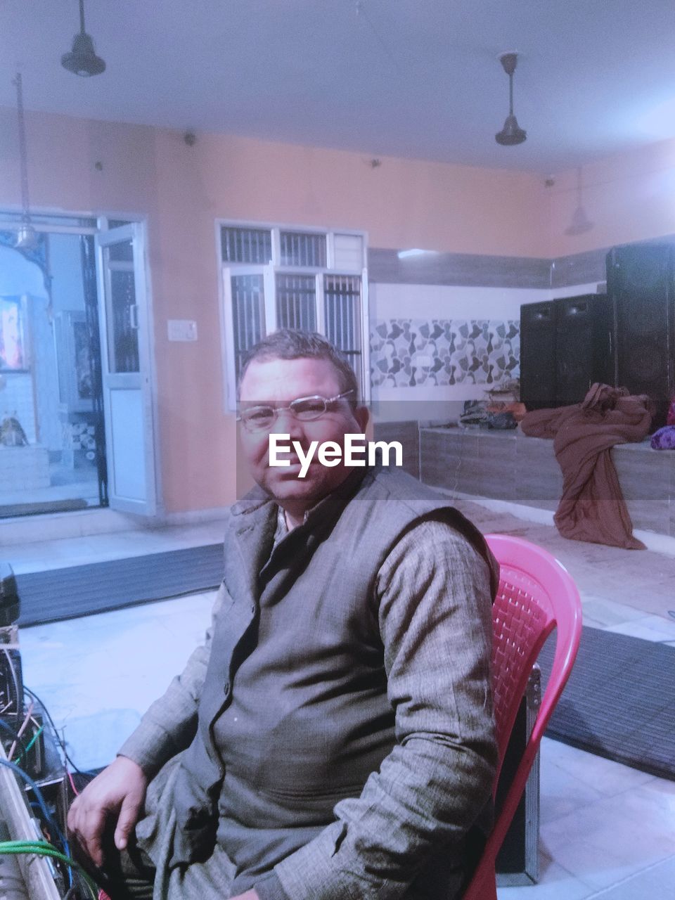 PORTRAIT OF MATURE MAN SITTING ON CHAIR IN CAFE