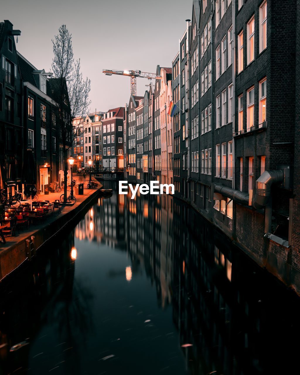 Reflection of illuminated buildings in canal at dusk