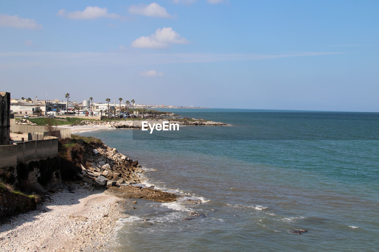 sea, water, sky, land, architecture, beach, shore, coast, vacation, ocean, nature, body of water, built structure, building exterior, scenics - nature, horizon, horizon over water, beauty in nature, travel destinations, cliff, building, travel, day, city, cloud, no people, tourism, terrain, outdoors, blue, wave, coastline, bay, tranquility, tranquil scene, sunlight, history, holiday, trip, idyllic
