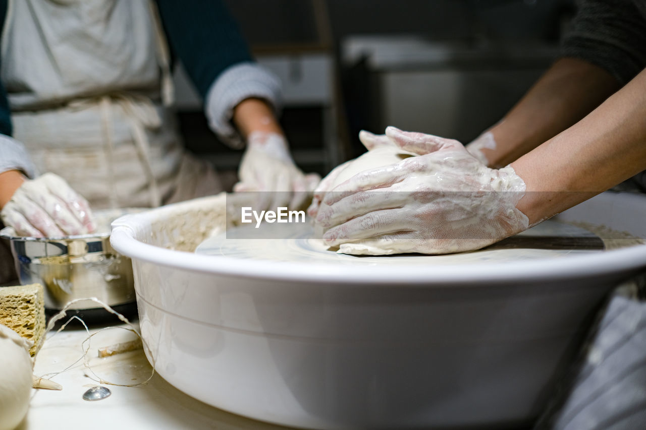 MIDSECTION OF PERSON HAVING FOOD IN KITCHEN