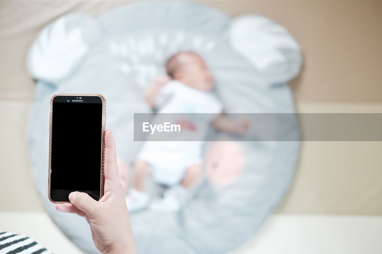 LOW ANGLE VIEW OF CHILD HOLDING MOBILE PHONE